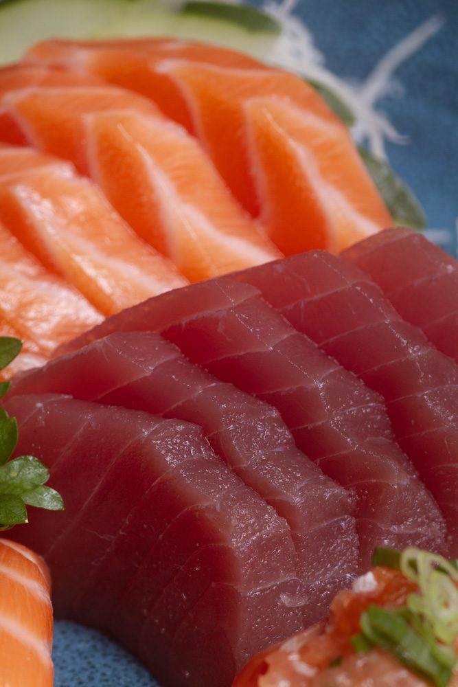 Close de lâminas de atum vermelho e salmão frescos, lado a lado